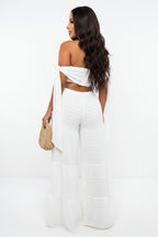 Woman wearing a white outfit with a cutout design on a white background