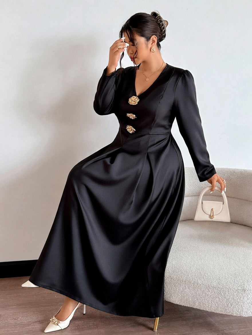 Woman wearing a black dress with gold buttons, holding a white handbag indoors.