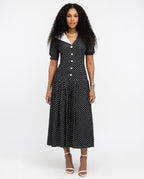 Woman wearing a black polka dot dress on a white background