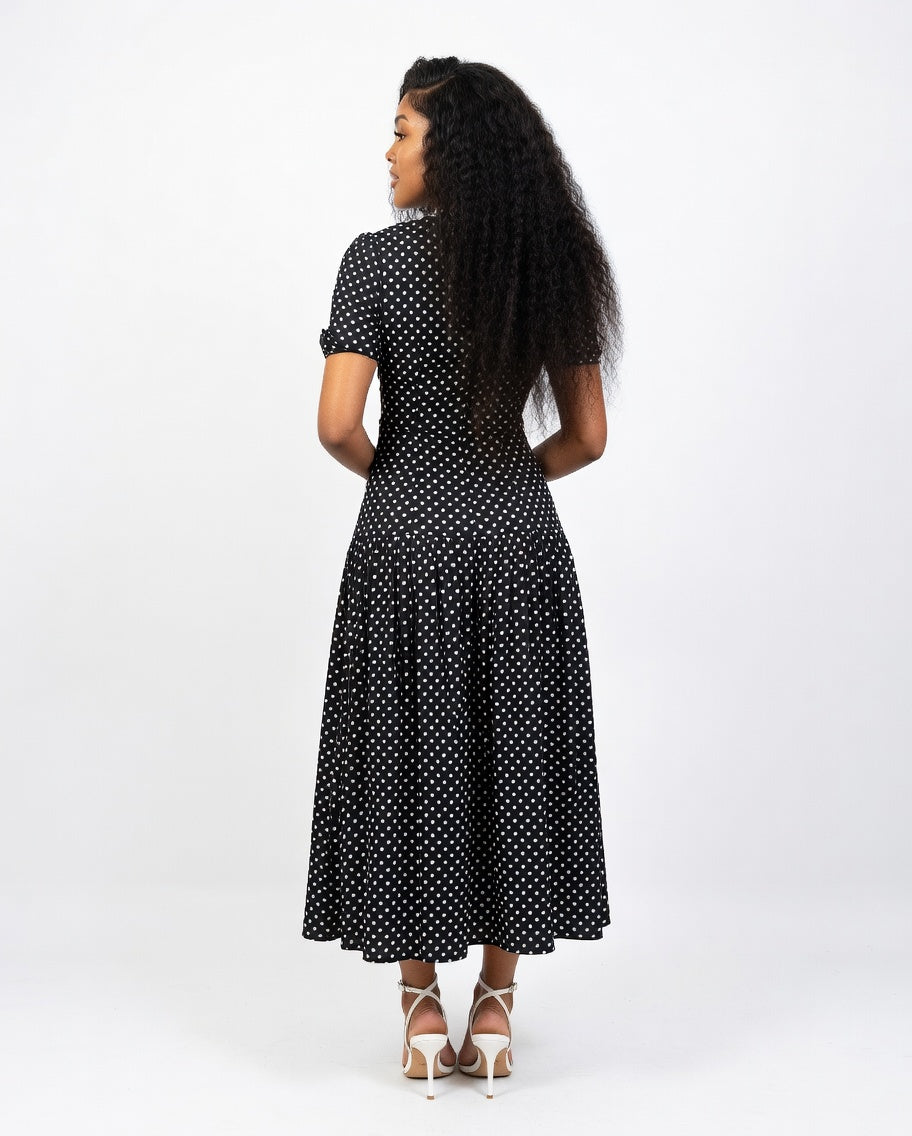 Woman wearing a black polka dot dress on a white background