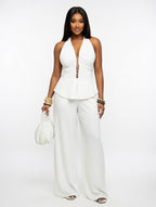 Woman wearing a white sleeveless top and wide-leg pants on a white background