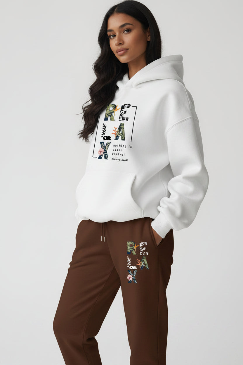 Woman wearing a white hoodie with colorful text design, holding a coffee cup against a plain background