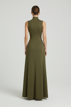 Woman wearing a green evening gown against a plain background