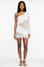 Woman wearing a white crochet one-shoulder dress on a white background