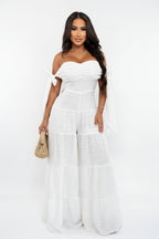 Woman wearing a white strapless jumpsuit on a white background