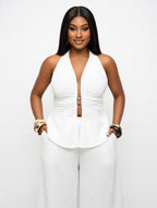 Woman wearing a white halter top and pants on a white background