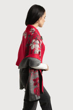 Woman wearing a red and gray floral patterned coat on a white background