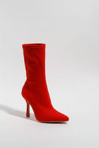 Red high-heeled sock boot on a white background