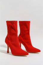 Red high-heeled ankle boots on a light gray background