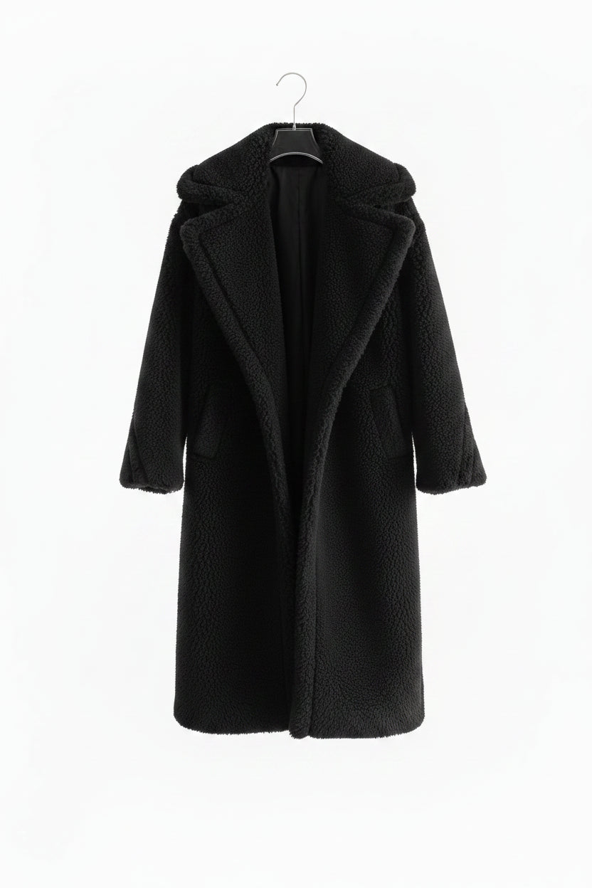 Black coat on a hanger against a white background