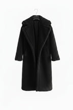Black coat on a hanger against a white background