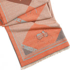 Folded fabric with geometric pattern and embroidered design on a white background
