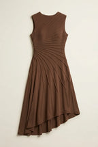 This sleeveless, brown midi dress features a crew neckline and a sophisticated sunray pin-tuck design that radiates outward across the fitted bodice. Crafted from a fluid, medium-weight fabric, the dress forms structural pleated lines that extend downward through an A-line silhouette, culminating in a dramatic asymmetrical high-low hemline that flows gracefully around the legs.