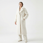 Woman wearing a long white coat on a white background