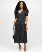 Woman wearing a black polka dot dress on a white background