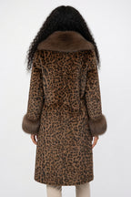 Leopard print coat with fur collar worn by a person on a white background