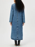 Long denim coat worn by a person on a white background