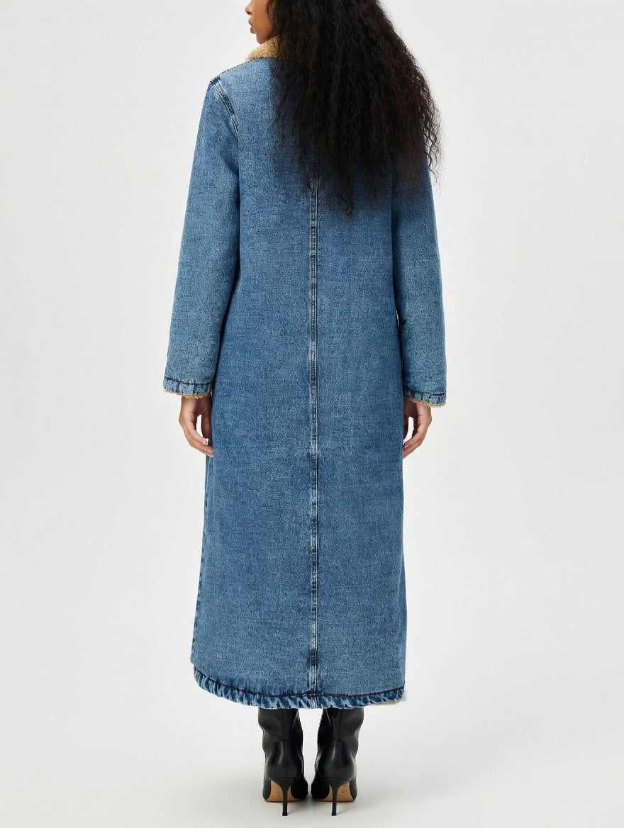 Long denim coat worn by a person on a white background