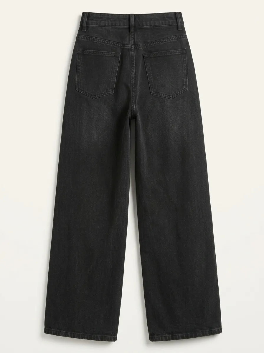 a pair of high-waisted, wide-leg jeans is crafted from a dark washed-black or washed-charcoal denim completely covered in a sparkling, all-over pattern of tiny silver rhinestones and crystal studs that scatter densely down the legs. 