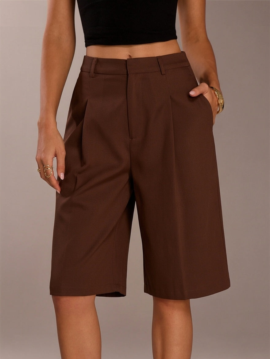 Brown shorts worn by a person on a neutral background