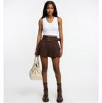 Woman wearing a white top, brown skirt, and boots on a white background