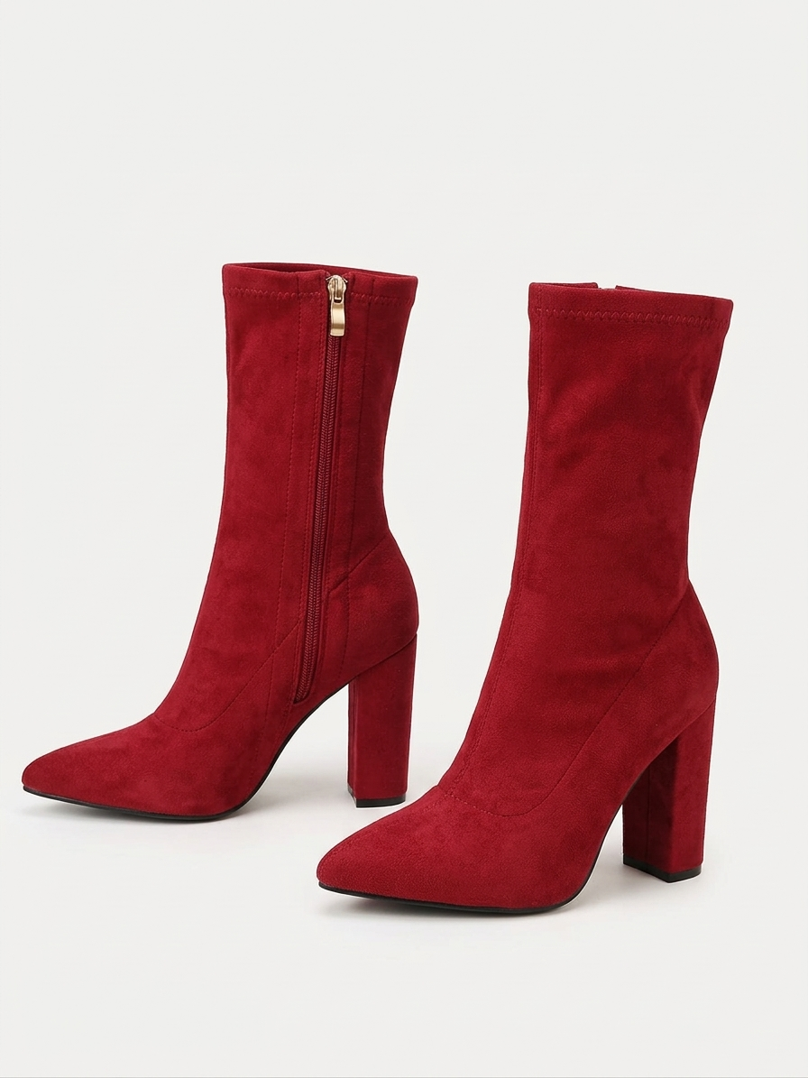 Red high-heeled boots with a gold zipper on a white background