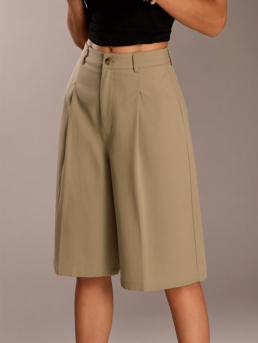 Person wearing beige shorts on a plain background