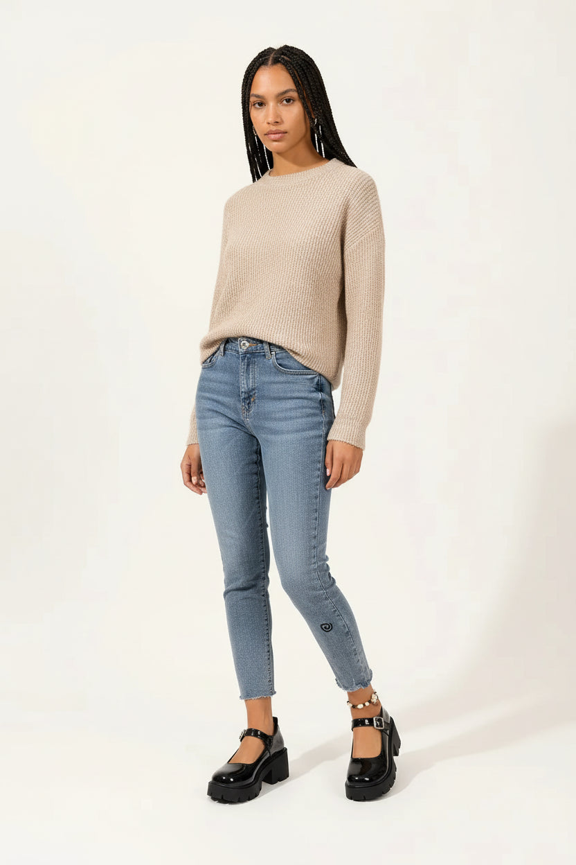 A person wearing glossy black Mary Jane platform shoes with chunky lug soles and buckle straps, paired with light blue cropped jeans on a clean white studio background.