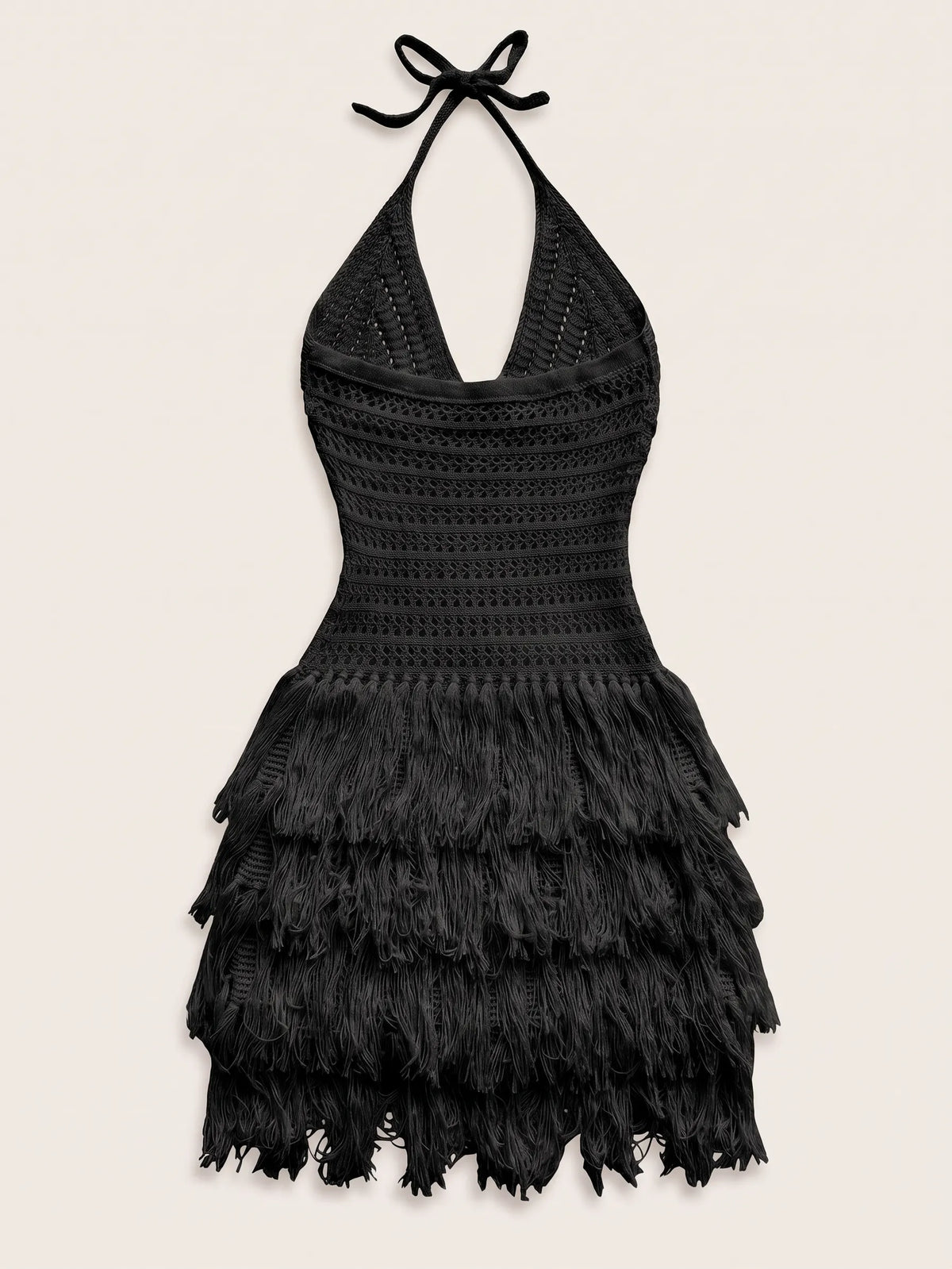 A black crochet halter mini dress with a tiered feathered skirt, displayed against a solid light beige background.