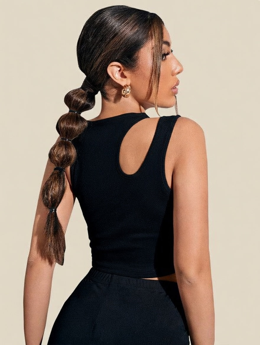 Woman with a side braid wearing a black sleeveless top against a beige background