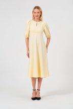 Woman wearing a yellow dress on a white background