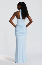 Woman wearing a light blue halter neck gown with a white background