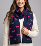Woman wearing a navy blue scarf with pink dog patterns on a gray background
