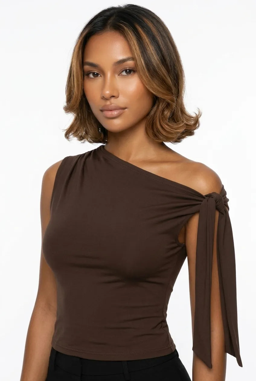 a dark brown asymmetric one-shoulder sleeveless top with subtle neck gathering and a draped tie detail on the left shoulder