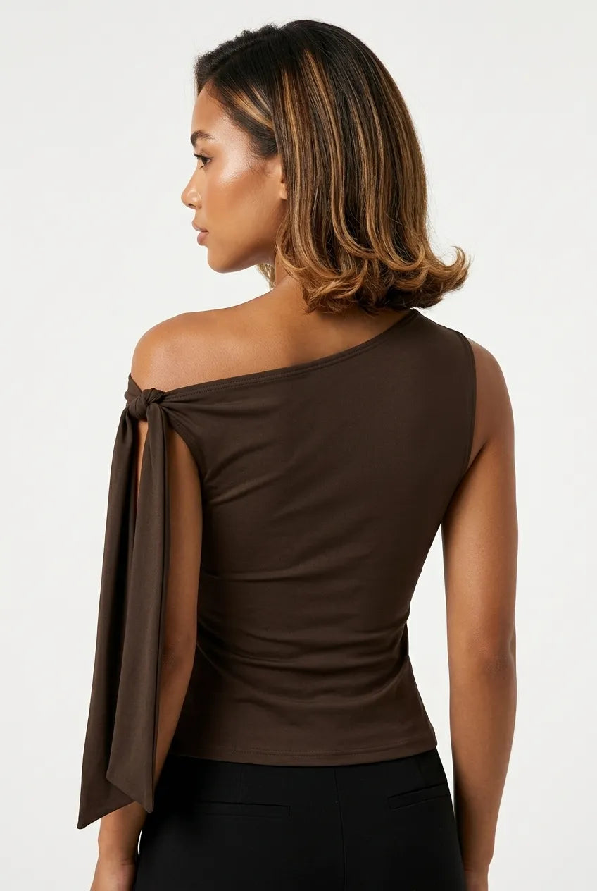 a dark brown asymmetric one-shoulder sleeveless top with subtle neck gathering and a draped tie detail on the left shoulder