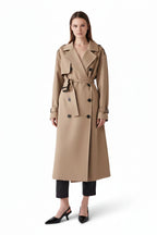 A female model wearing a beige belt trench coat with a lapel neckline, double-breasted design, and a belt.