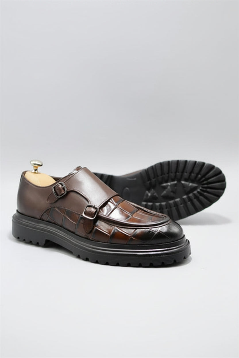 Brown leather shoes with a glossy finish on a light gray background