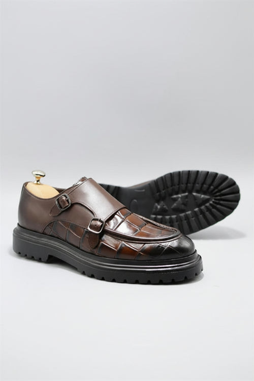 Brown leather shoes with a glossy finish on a light gray background