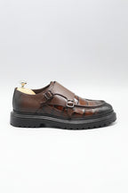 Brown leather sandal with a buckle on a white background