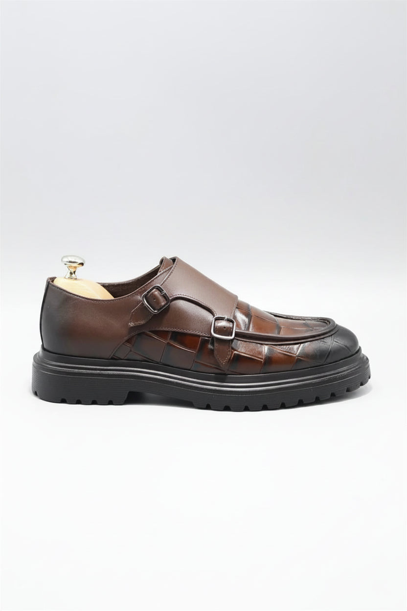 Brown leather sandal with a buckle on a white background