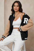 Woman wearing a black and beige varsity jacket with 'R' on a beige background