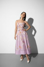 Woman wearing a floral dress against a white background