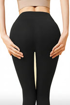 Person wearing black leggings on a white background