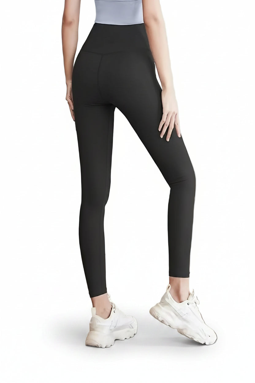 Person wearing black leggings and white sneakers on a white background