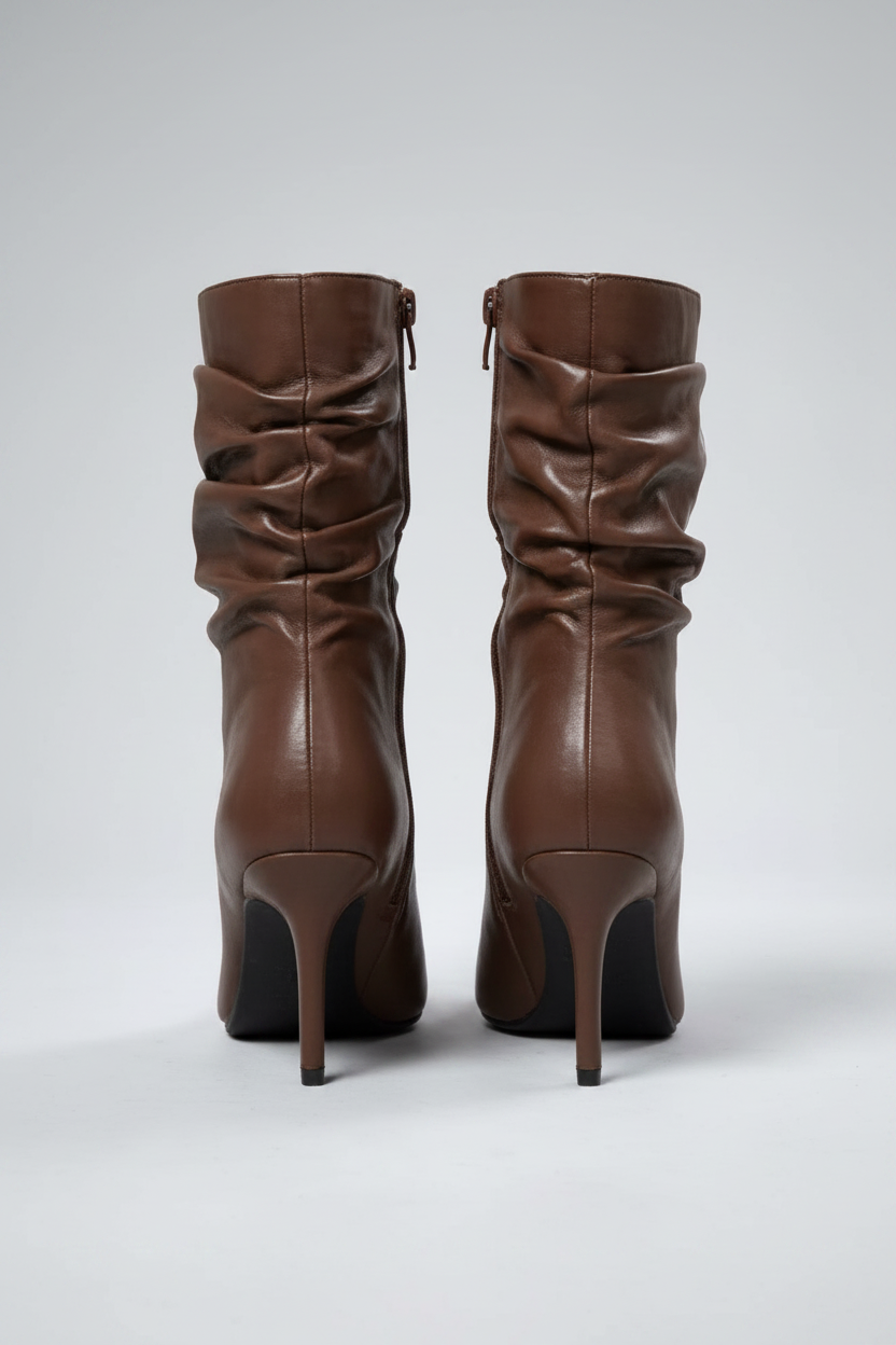 Pair of brown high-heeled boots on a light gray background