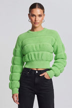 woman wearing a vibrant lime-green, textured knit sweater.