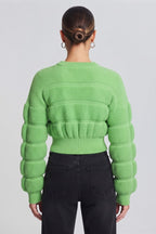 woman wearing a vibrant lime-green, textured knit sweater.