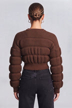 woman wearing a brown, textured knit sweater.