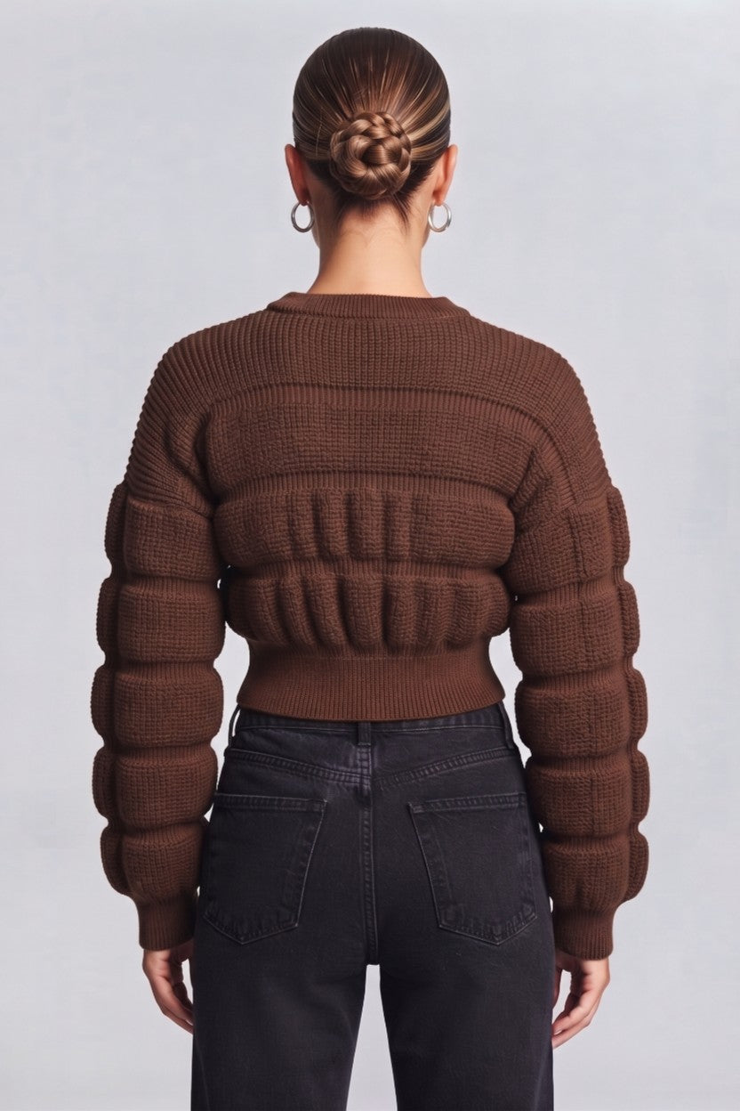 woman wearing a brown, textured knit sweater.