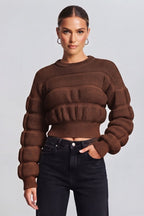 woman wearing a brown, textured knit sweater.